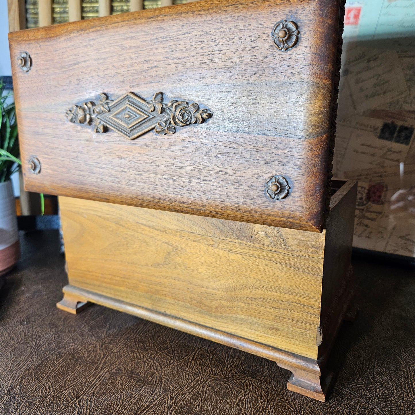 Wooden music box with carved decorative on a textured surface