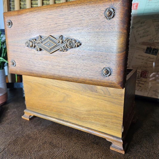 Wooden music box with carved decorative on a textured surface