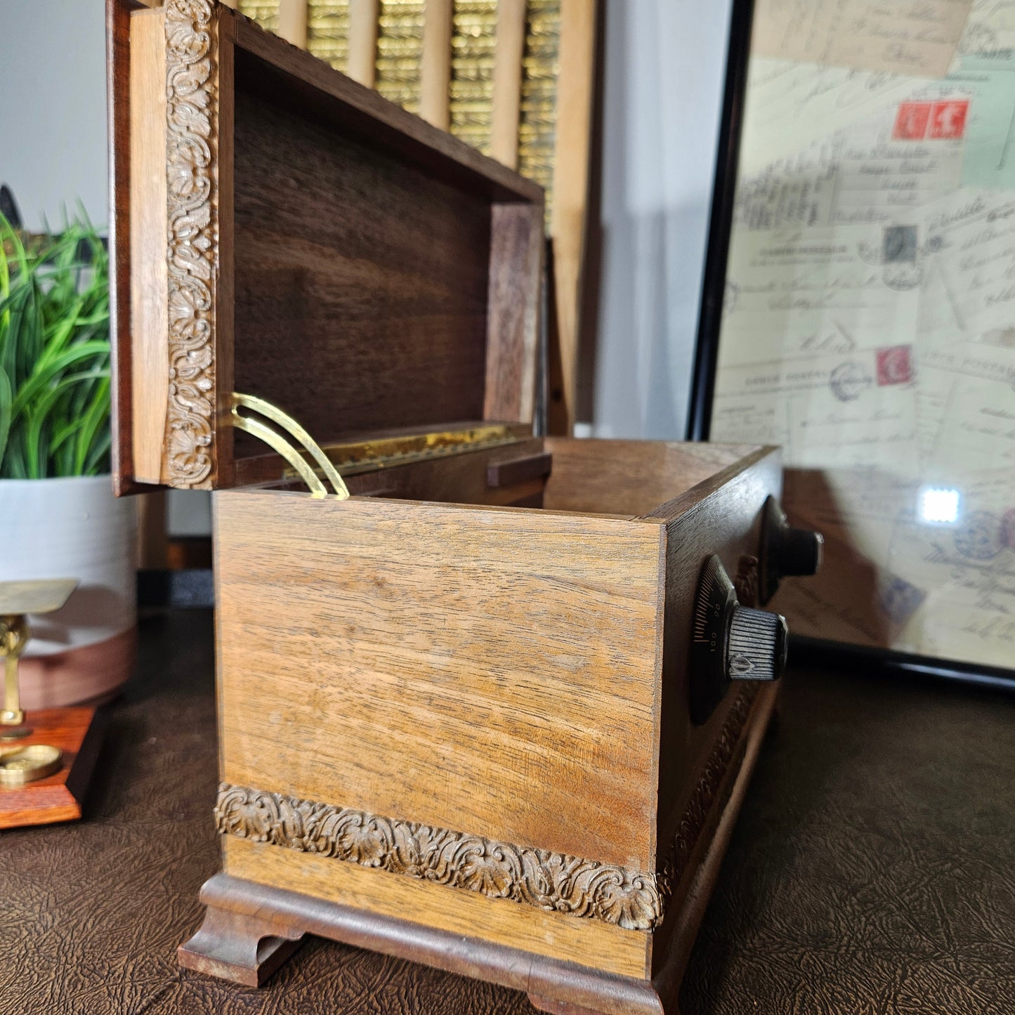 Close-up of a wooden musicbox with a map in the background