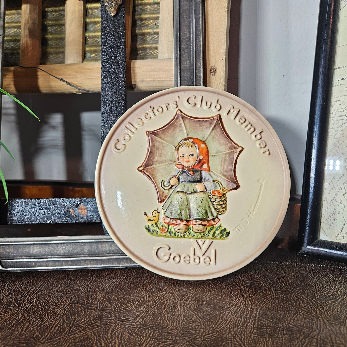 Decorative plate with a girl holding an umbrella design, labeled 'Goebel Collector's Club Member'.