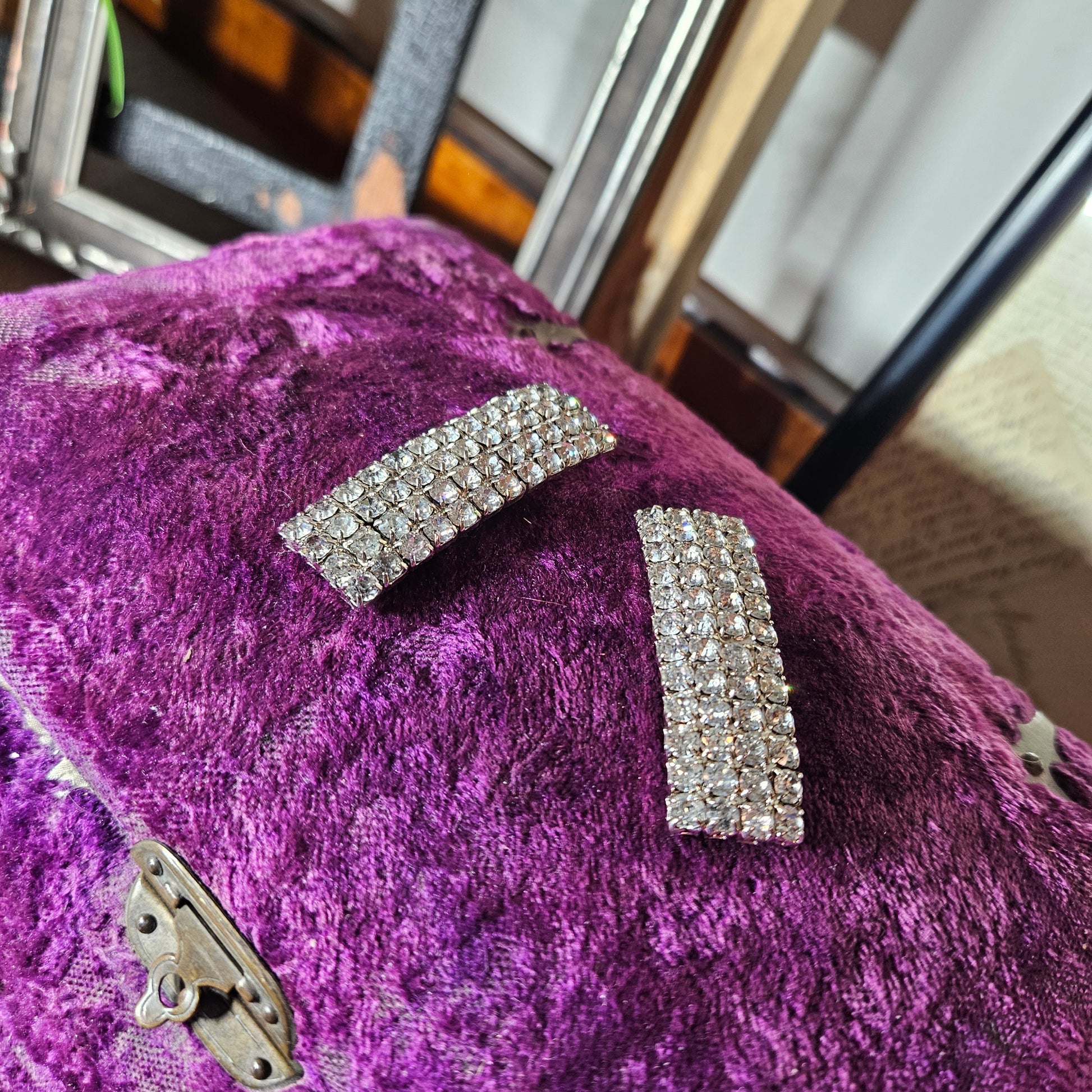 decorative silver brooches on a blurred indoor background