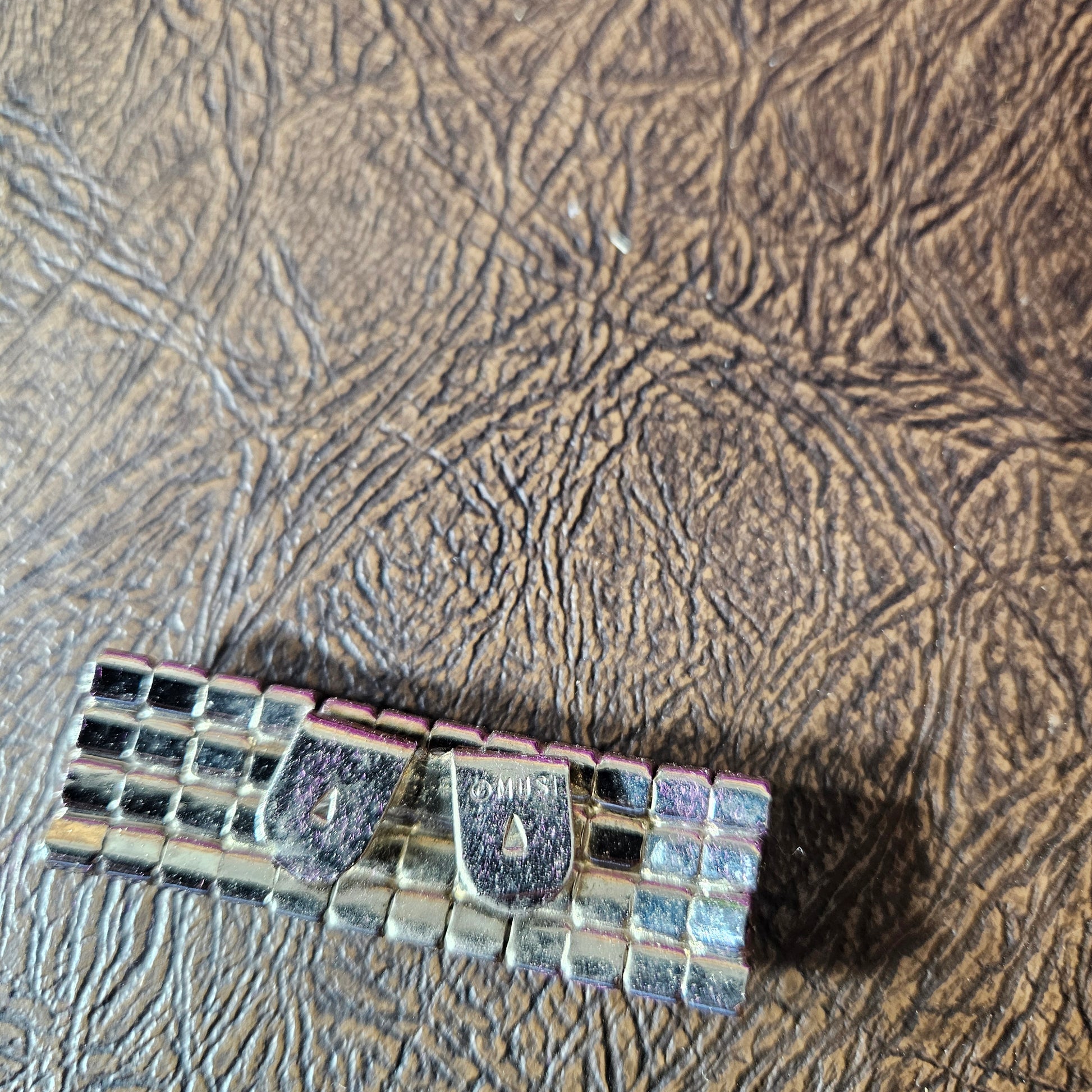 Decorative clip with mosaic pattern on a textured surface