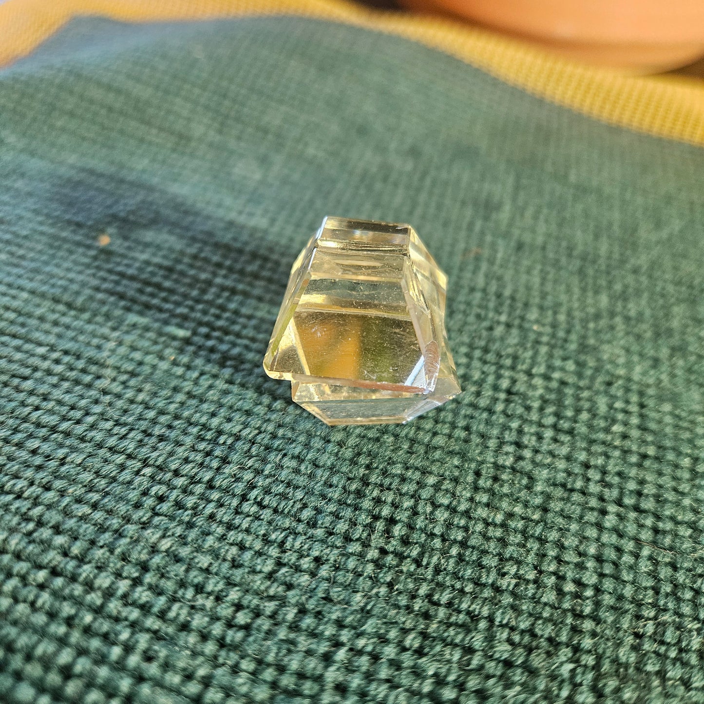 Faceted crystal on a textured green fabric background