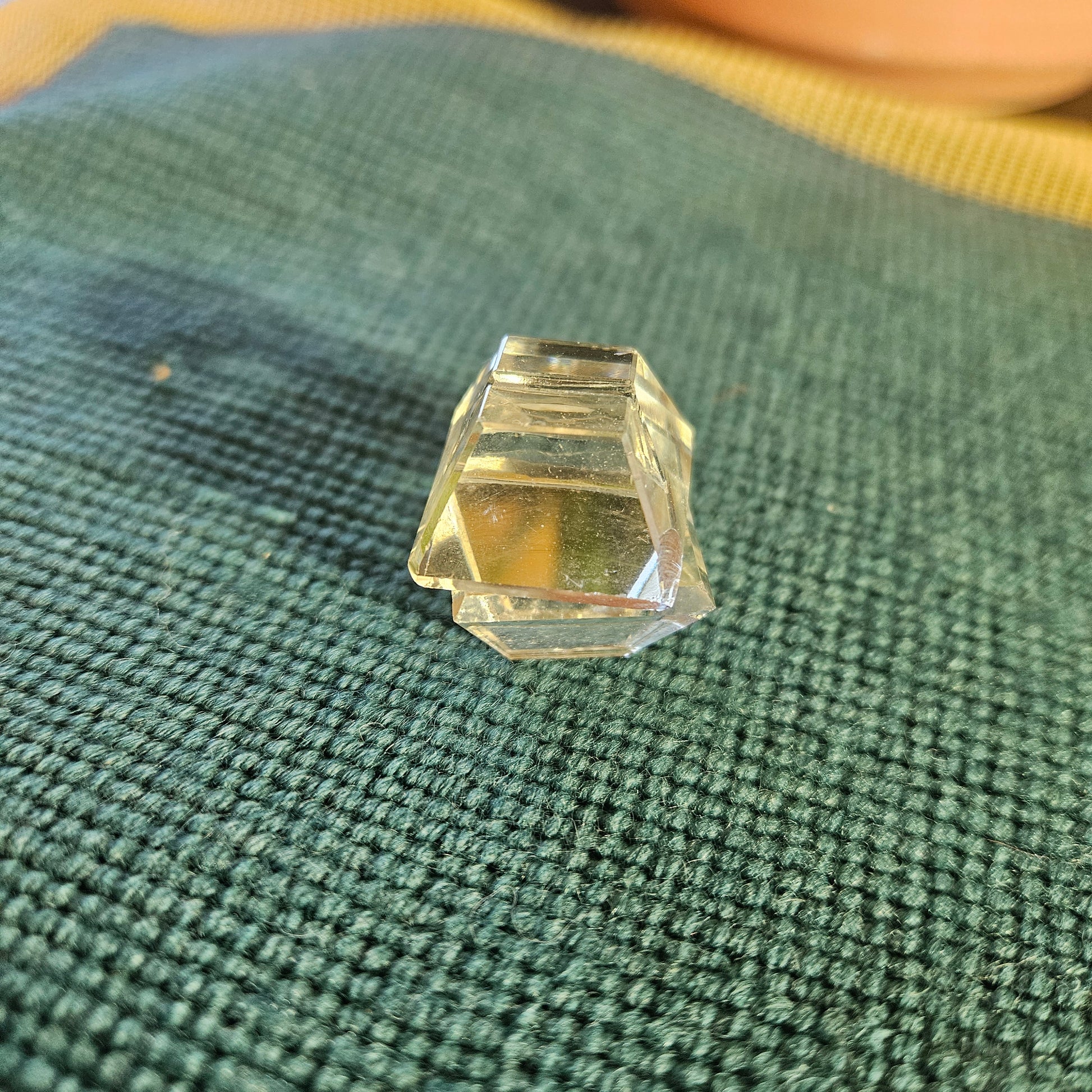 Faceted crystal on a textured green fabric background