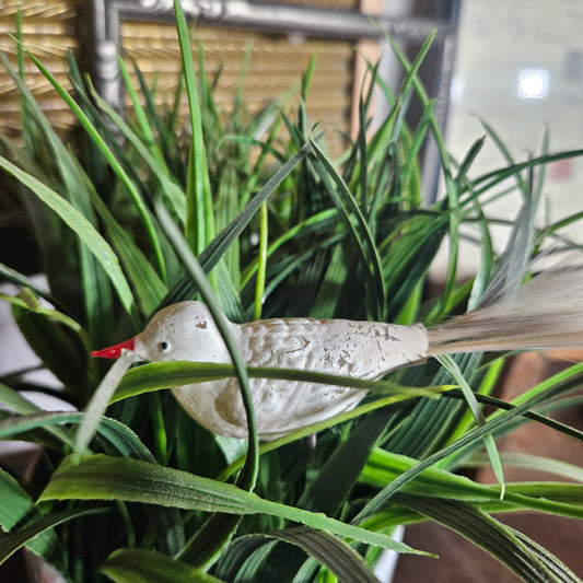 Decorative bird ornament hanging from a plant