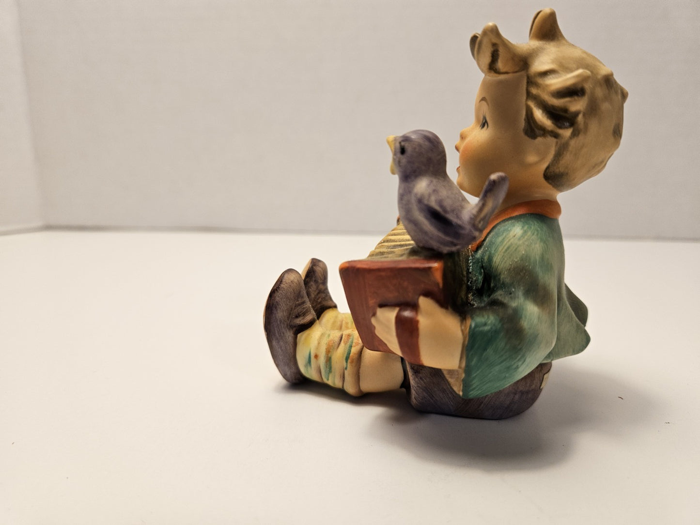 Figurine of a child with a bird on a white background