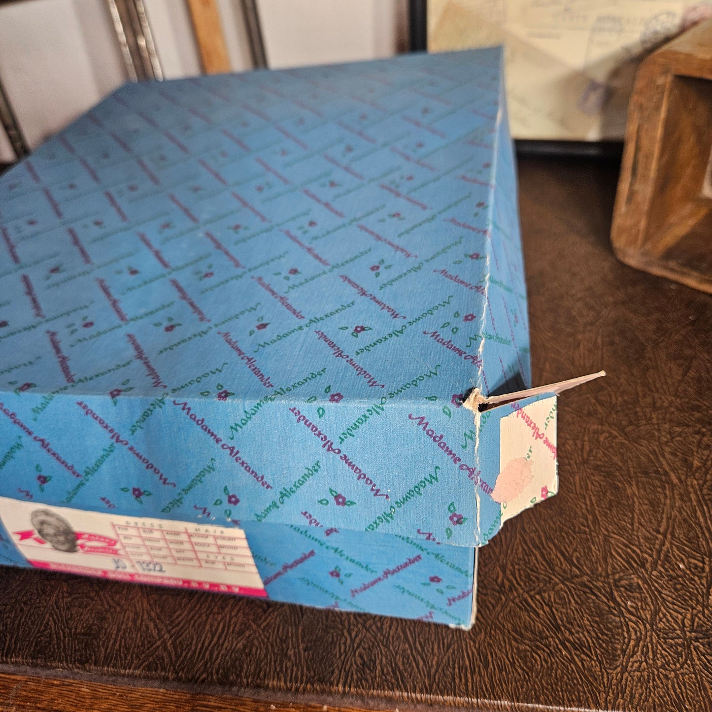 Blue paper bag with text and a pink label on a wooden surface