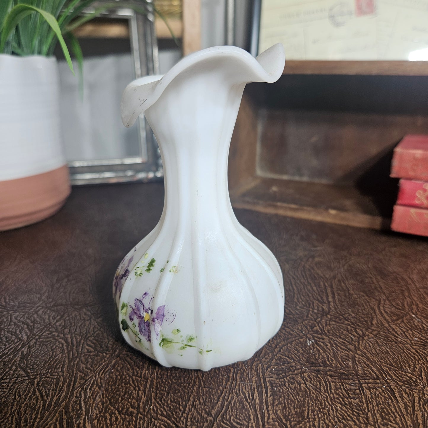 White ceramic vase with floral design on a textured surface