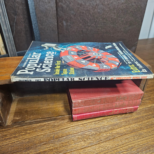 Book titled 'Popular Science' on a wooden shelf
