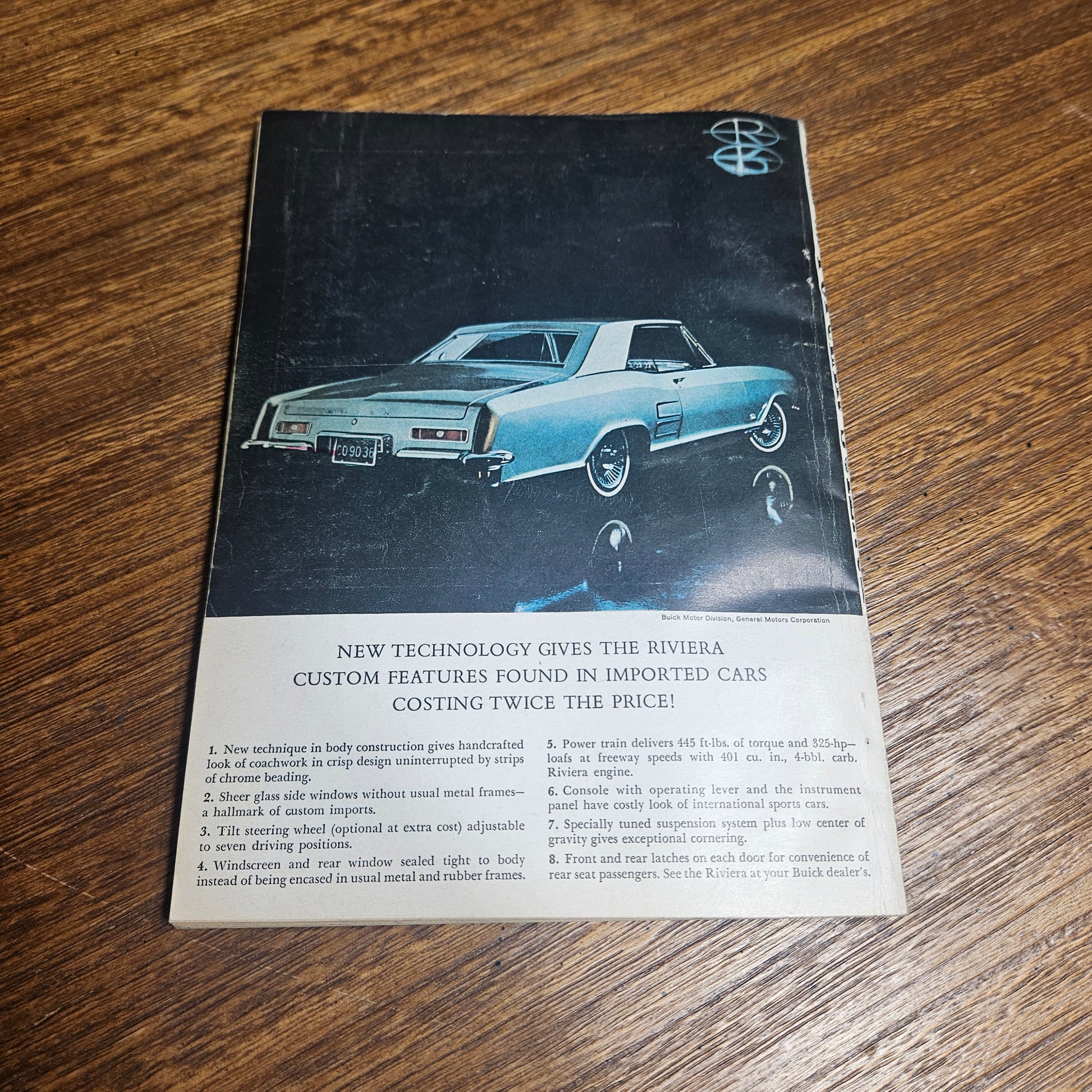 Vintage advertisement for a car on a wooden surface