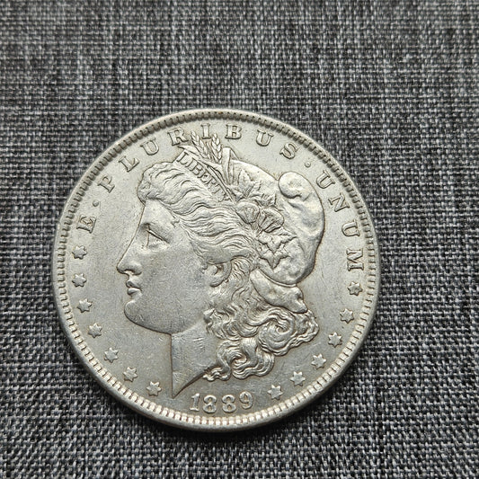 Silver coin with a profile of a woman and 'E Pluribus Unum' text on a textured gray background