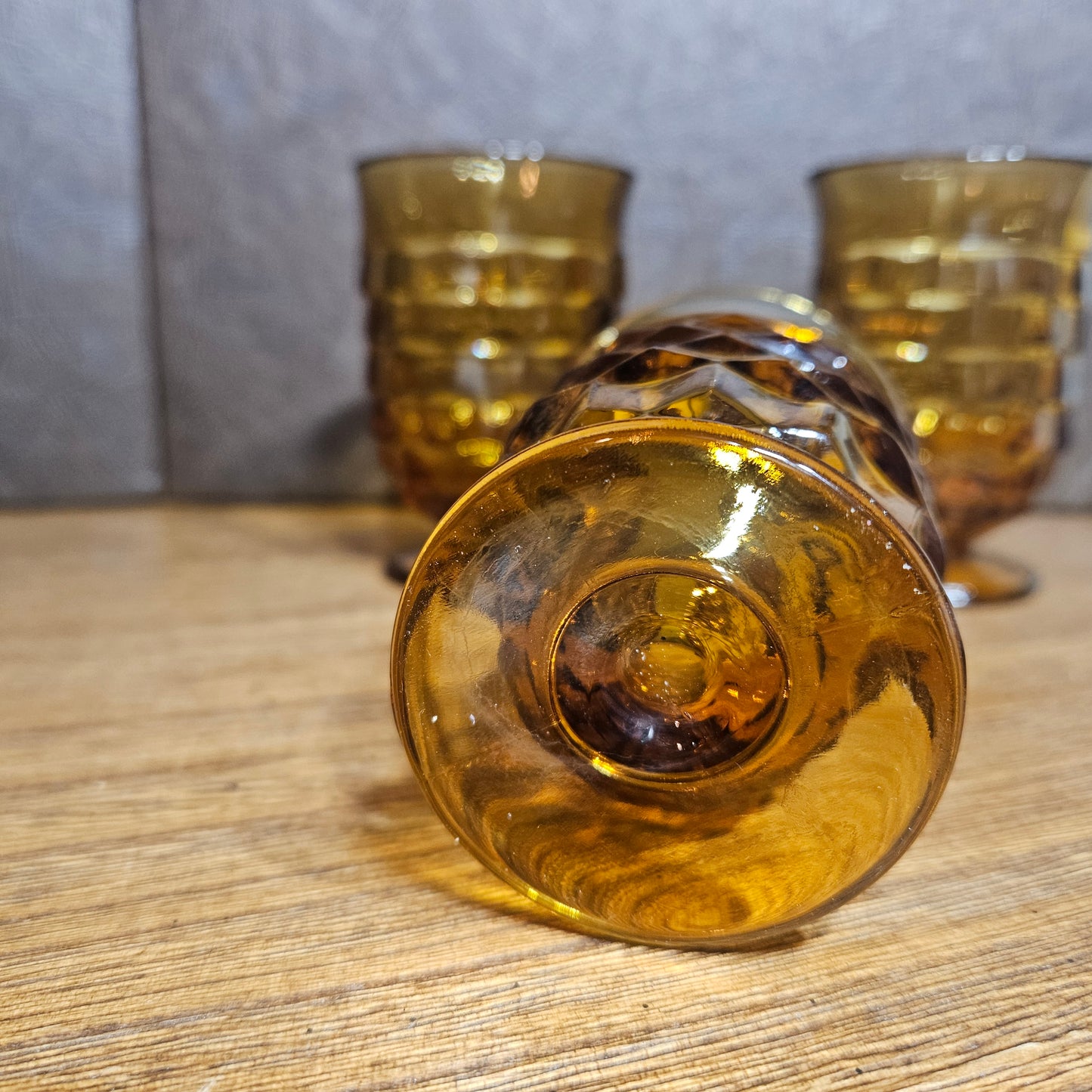 Amber glass tumblers on a wooden surface with a neutral background
