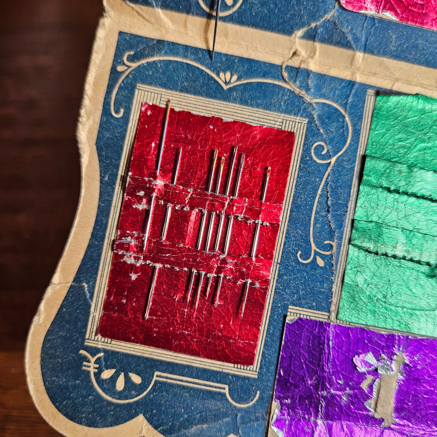 Antique sewing needle booklet with colorful compartments